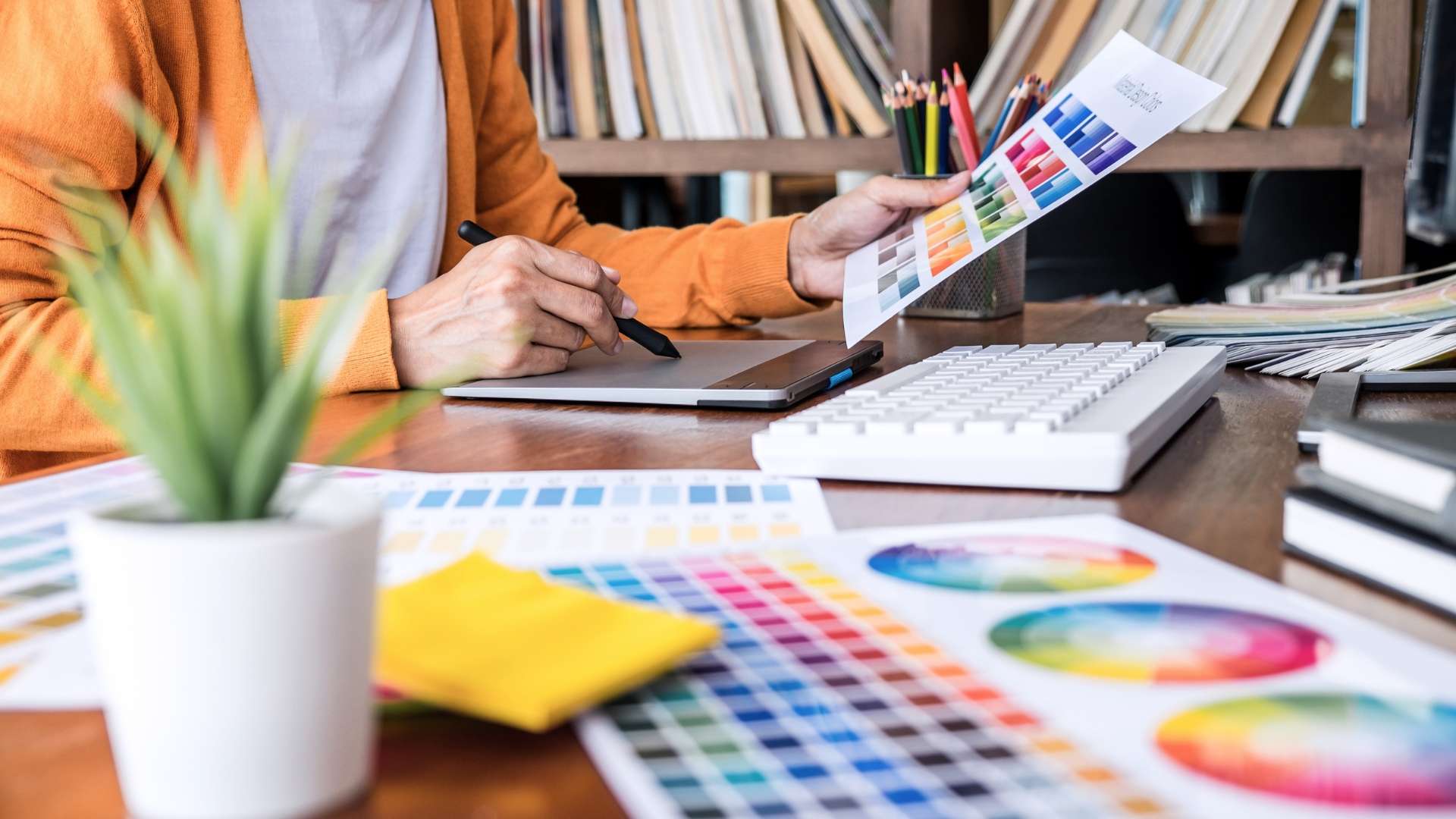 Person looking over a Pantone sheet with a variety of colours - Kuluki Fashion Marketing.